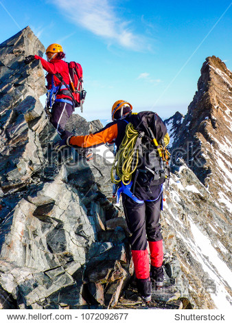 male and female mountain climber on an exposed rocky summit