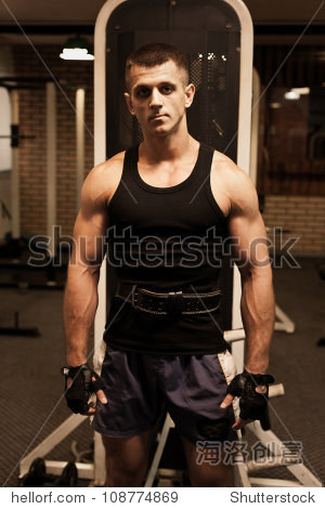 portrait of young muscular man in gym