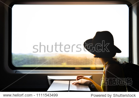 A beautiful hipster asian woman travelling on the train. Sitting on the black leather cozy comfort seat in the business class boky of the train in Europe. Tourist travel concept.