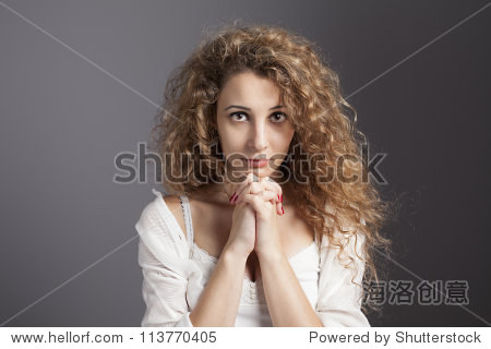 young blonde woman with her hands together praying