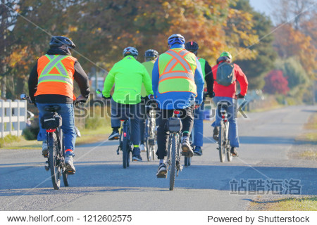 A group of cyclist wear bright  reflective clothing to ensure visibility and safety while they cycle. 