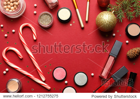 Flat lay composition with makeup products and Christmas decor on color background. Space for text