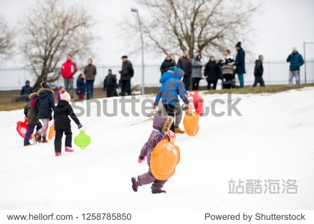 kids riding on snow slides in winter time