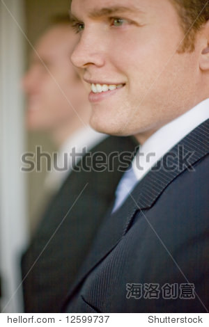 close up of two businessmen wearing suits smiling in profile