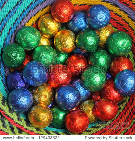 wrapped colorful chocolate balls in a basket christmas candies