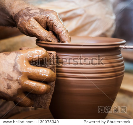potter hands making in clay on pottery wheel.