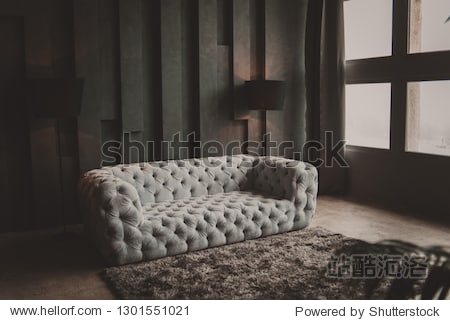 soft velvet grey sofa. minimalistic loft living room. textured gray wall. black floor lamp. gray rug near couch