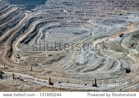 close up of quarry extracting iron ore with heavy trucks