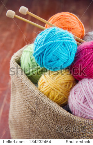 woolen balls of yarn and wooden knitting needles in a rustic