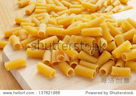a pile of uncooked uncooked penne pasta on a kitchen wooden