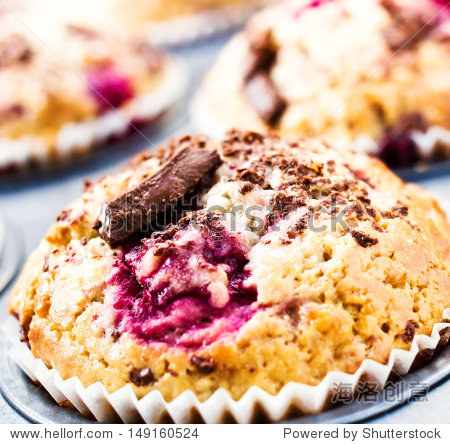 cherry muffins with chocolate sprinkles in baking tin. macro.