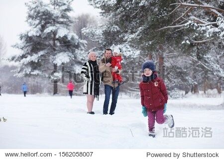 Young family with children are walking in the winter park. Winter walk of parents with children. Walking on holiday weekend in the winter.