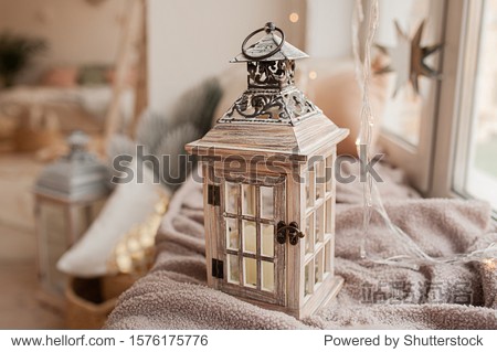 home decoration wooden candlestick in the form of a street lamp on the background of a cozy interior in the style of boho