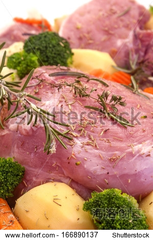 fresh pork meat with a variety of vegetables on a white back