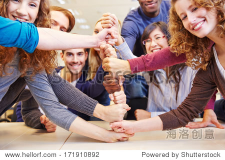 students stacking fists for cooperation and teamwork in a