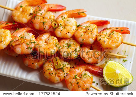 fried spicy shrimps with garlic and herbs on bamboo skewers