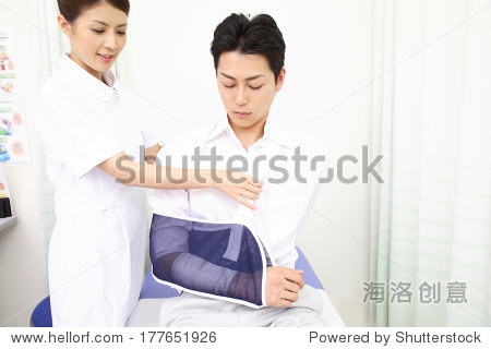 Japanese Nurse putting a patient's arm in a cas