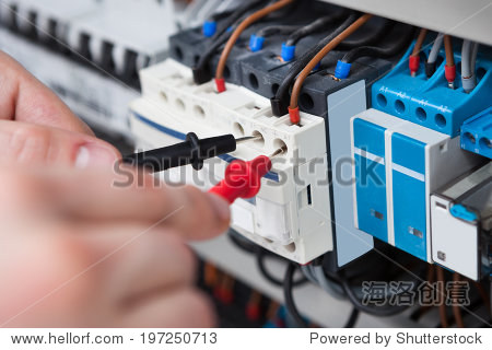 closeup of male electrician examining fusebox with multimeter