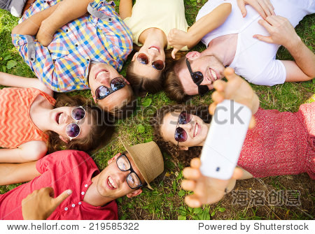 group of young people having fun in park lying on the grass