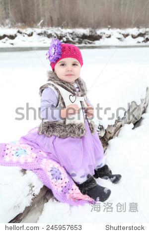 little girl sitting outside in the snow