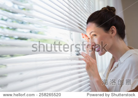 woman peeking through the blinds from inside - 站酷海洛正版图片