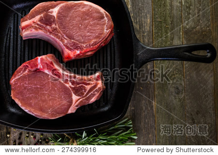 organic pork lion chops of thick cut on cast iron frying pan.