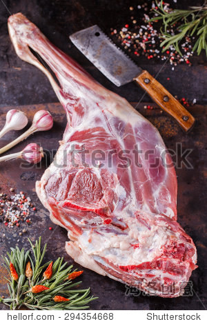 raw leg of lamb with spices and rosemary.