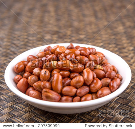 deep fried peanuts in white bowl over rustic wicker background