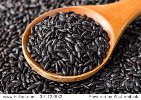uncooked black rice in the wooden spoon, (large depth of field