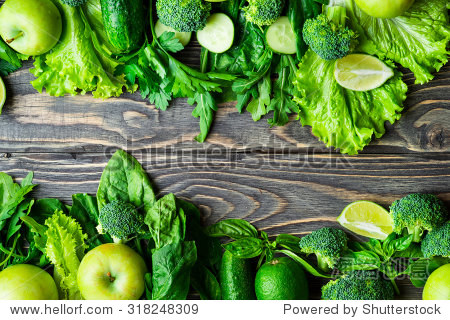 fresh green vegetables and fruits on vintage wooden background.
