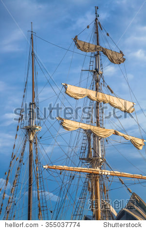 sails rolled up the mast on a ship in the blue sky, new south