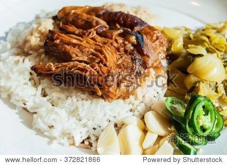 closeup stewed pork leg on rice with garlic chili and pickled