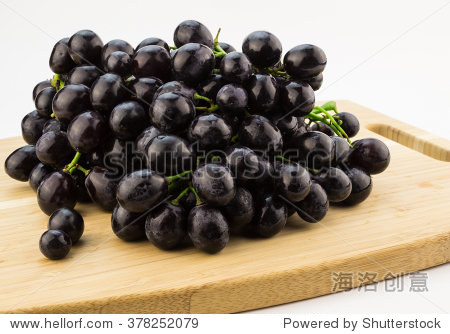 photo of big bunch of black grapes on wood cutting board - 图片