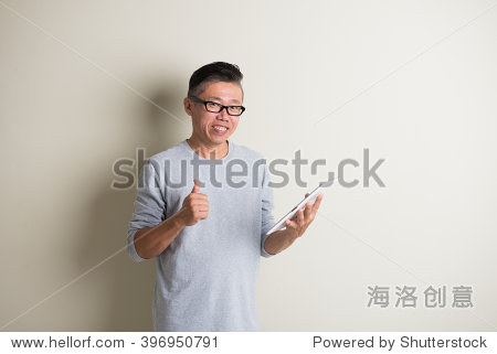 matured asian male using tablet