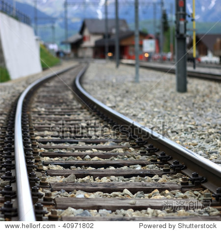 railroad track with train station in the background