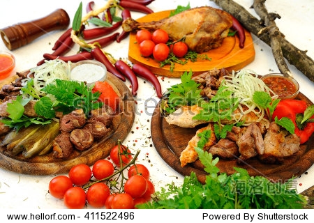 mouth-watering meat dishes grilled with vegetables on a white