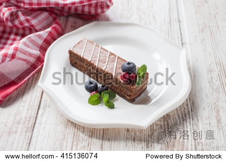 piece of chocolate cake with berries in a plate on a table