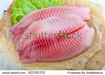 raw tilapia fish fillet with thyme ready for cooking