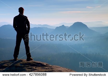 hiker is standing on the peak of sandstone rock