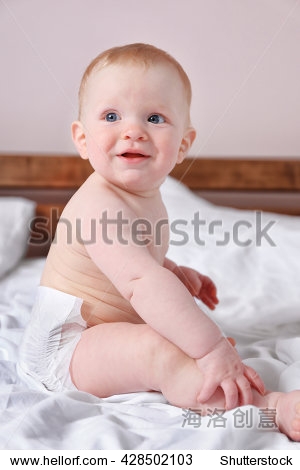 adorable baby sitting on parents bed, close up