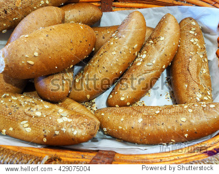freshly baked whole wheat buns on display in a basket at the