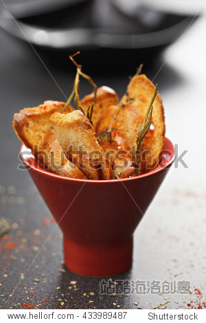 toasted bread with herbs and spices in a red bowl - 站酷海洛正版