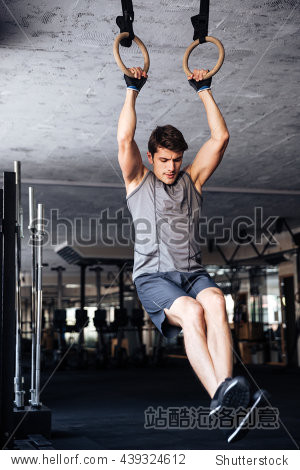fitness handsome man doing dipping exercise using rings in the
