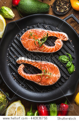 raw uncooked salmon fish with vegetables, herbs and spices in
