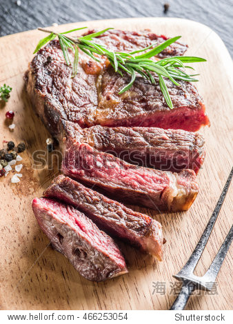 medium ribeye steak with spices on the wooden tray.