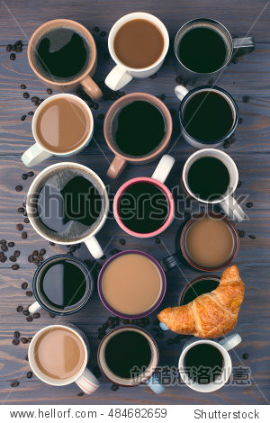 many cups of coffee and one fresh croissant on wooden background