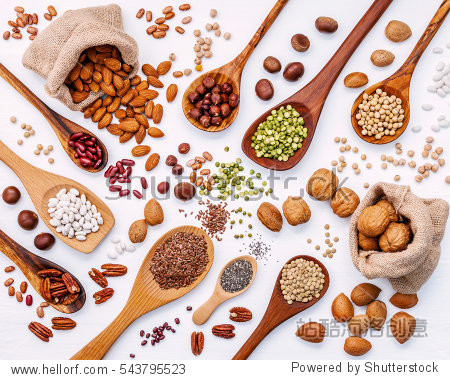 various legumes and different kinds of nuts in spoons