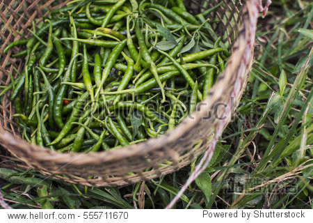 closeup of some green chillies mixed in the basket.