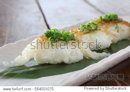 flounder nigiri sushi on white long plate, with chopped green