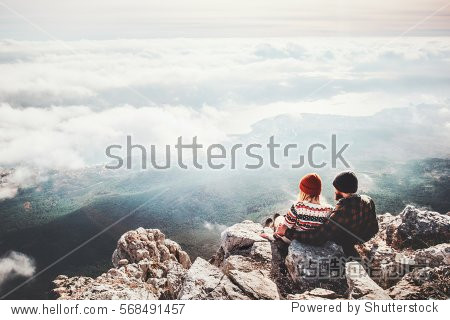 Couple travelers Man and Woman sitting on cliff relaxing mountains and clouds aerial view Love and Travel happy emotions Lifestyle concept. Young family traveling active adventure vacations
